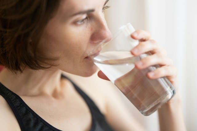 Lady drinking water to stay hydrated